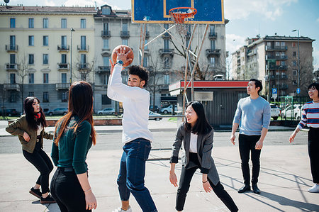 simsearch:649-09268937,k - Young female and male adult friends playing basketball on city court Foto de stock - Sin royalties Premium, Código: 649-09258081