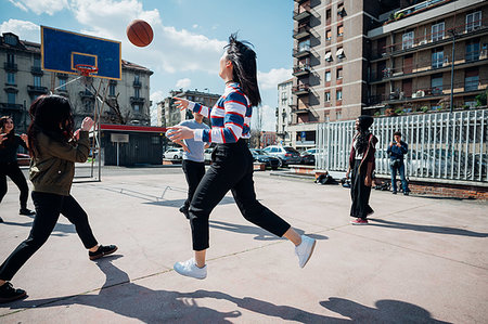 simsearch:649-08969957,k - Young female and male adult friends playing basketball on city basketball court Photographie de stock - Premium Libres de Droits, Code: 649-09258090