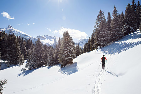 simsearch:649-07596377,k - Mature man snowshoeing in snow covered mountain forest, distant rear view, Styria, Tyrol, Austria Stock Photo - Premium Royalty-Free, Code: 649-09258149