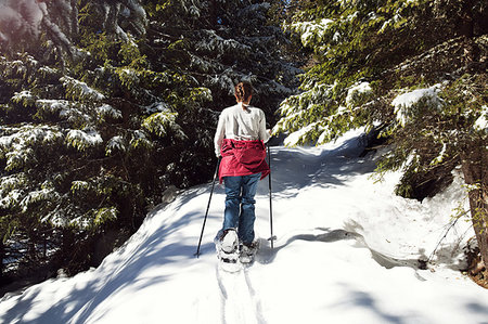 snowshoer (female) - Teenage girl snowshoeing in snow covered mountain forest, rear view, Styria, Tyrol, Austria Stock Photo - Premium Royalty-Free, Code: 649-09258156