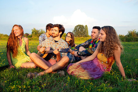 simsearch:649-08565670,k - Group of young adults sitting in field listening to acoustic guitar Stock Photo - Premium Royalty-Free, Code: 649-09258177