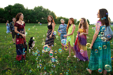 simsearch:614-06897021,k - Large group of happy young adults standing in field with floating bubbles Stock Photo - Premium Royalty-Free, Code: 649-09258178