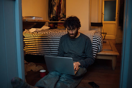 simsearch:649-09258330,k - Bearded young man using laptop in bedroom Stock Photo - Premium Royalty-Free, Code: 649-09258325