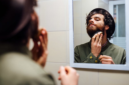 simsearch:649-09258330,k - Bearded young man brushing beard in bathroom Stock Photo - Premium Royalty-Free, Code: 649-09258333