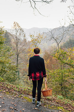 Woman with basket on hillside road, Rezzago, Lombardy, Italy Stock Photo - Premium Royalty-Free, Code: 649-09250035
