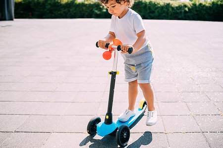 simsearch:649-09251433,k - Toddler riding push scooter in park Photographie de stock - Premium Libres de Droits, Code: 649-09250125