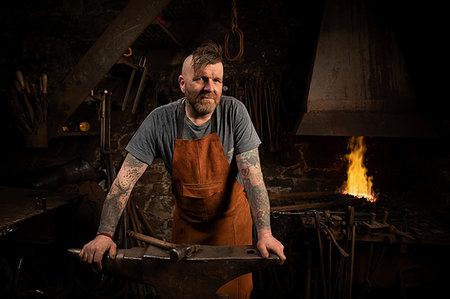 simsearch:649-09026034,k - Mature male blacksmith leaning against anvil in workshop, portrait Photographie de stock - Premium Libres de Droits, Code: 649-09250240