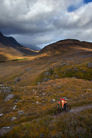 simsearch:649-08662224,k - Male mountain biker biking on dirt track in mountain valley landscape, elevated view,  Achnasheen, Scottish Highlands, Scotland Stock Photo - Premium Royalty-Free, Code: 649-09250276