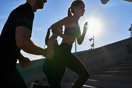 simsearch:614-05650886,k - Friends jogging up steps in sports stadium Foto de stock - Sin royalties Premium, Código: 649-09250776