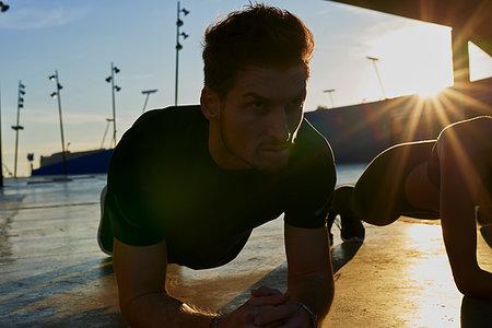 simsearch:649-06844931,k - Friends doing plank in sports stadium at sunset Foto de stock - Sin royalties Premium, Código: 649-09250810