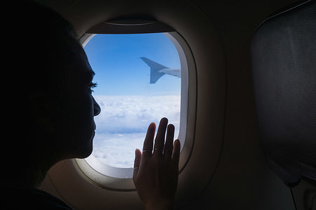 simsearch:649-08860216,k - Woman travelling in airplane, looking out window Fotografie stock - Premium Royalty-Free, Codice: 649-09250916