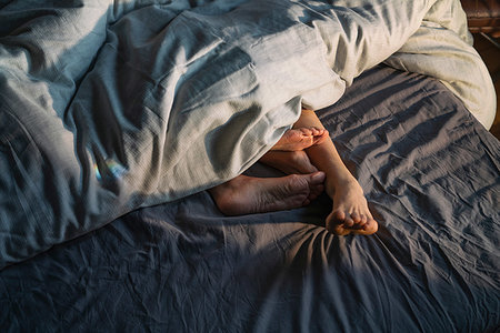 Couple's feet sticking out from under duvet in bed Photographie de stock - Premium Libres de Droits, Code: 649-09250990