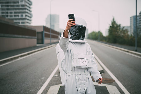 Astronaut taking selfie in middle of road Foto de stock - Sin royalties Premium, Código: 649-09251035