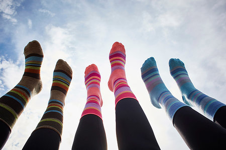 simsearch:649-07437570,k - Three young women in striped socks with legs raised against sunlit sky, cropped view of legs Stock Photo - Premium Royalty-Free, Code: 649-09251314