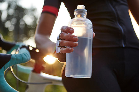 simsearch:614-08684819,k - Female cyclist holding water bottle, mid section Foto de stock - Royalty Free Premium, Número: 649-09251311
