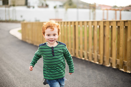 simsearch:649-09251433,k - Boy running on road in residential area Photographie de stock - Premium Libres de Droits, Code: 649-09251431