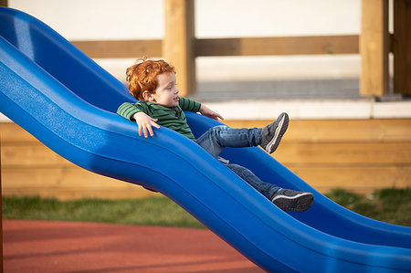 simsearch:649-09251433,k - Boy playing on slide in playground Photographie de stock - Premium Libres de Droits, Code: 649-09251445