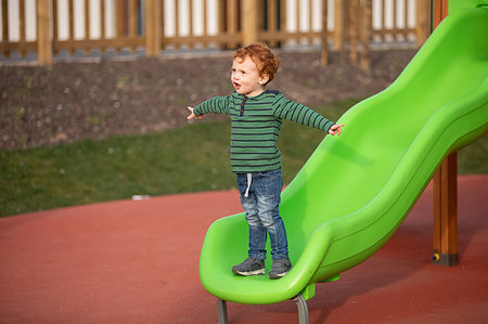 simsearch:649-09251433,k - Boy playing on slide in playground Photographie de stock - Premium Libres de Droits, Code: 649-09251447