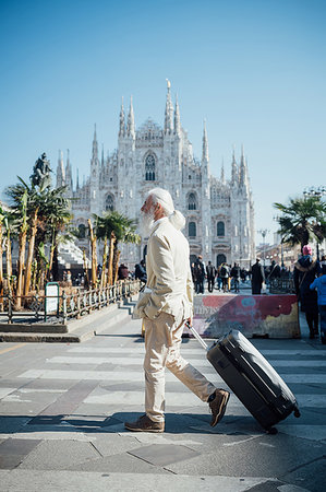 simsearch:649-09257678,k - Senior businessman with wheeled luggage passing Milan Cathedral in background, Milano, Lombardia, Italy Photographie de stock - Premium Libres de Droits, Code: 649-09251553