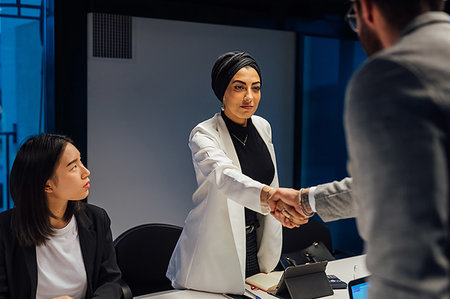 simsearch:649-09251667,k - Businesswoman and male client shaking hands over conference table meeting Photographie de stock - Premium Libres de Droits, Code: 649-09251611