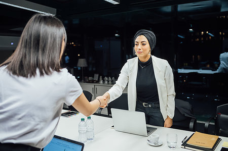 simsearch:614-08821459,k - Businesswomen shaking hands over conference table Foto de stock - Royalty Free Premium, Número: 649-09251677