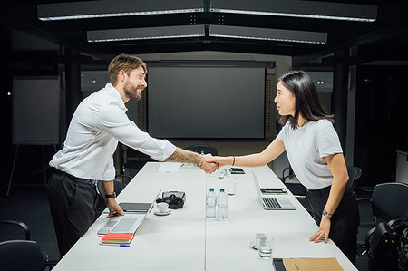 simsearch:649-09251667,k - Businesswoman and man shaking hands over conference table Photographie de stock - Premium Libres de Droits, Code: 649-09251671