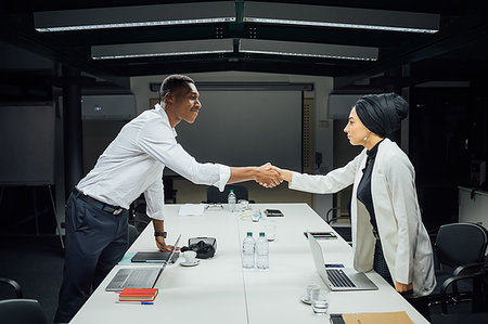 simsearch:649-09251667,k - Businessman and woman shaking hands over conference table Photographie de stock - Premium Libres de Droits, Code: 649-09251673