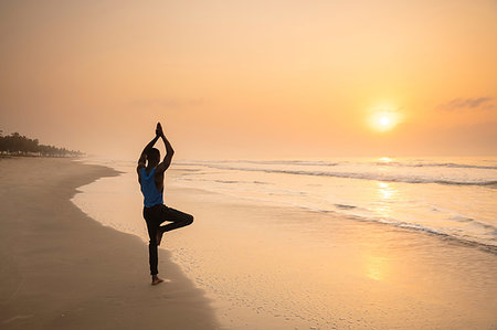 simsearch:632-05816759,k - Man practising yoga on beach Photographie de stock - Premium Libres de Droits, Code: 649-09251937