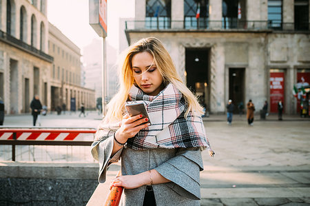 simsearch:649-08969944,k - Young woman looking at smartphone on city street Photographie de stock - Premium Libres de Droits, Code: 649-09252018