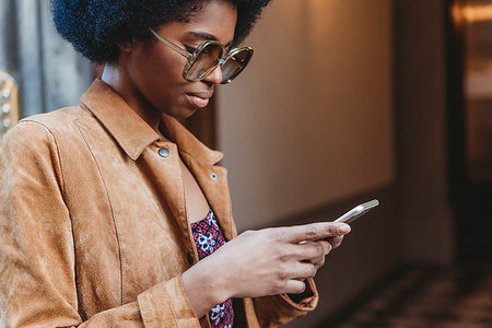 simsearch:649-09251527,k - Young woman with afro hair using smartphone in front of building Stock Photo - Premium Royalty-Free, Code: 649-09268445