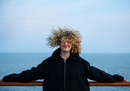 Teenage girl leaning against handrail on windy day Stockbilder - Premium RF Lizenzfrei, Bildnummer: 649-09268766