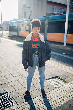 simsearch:649-09268931,k - Cool young woman on sunlit urban sidewalk, portrait Fotografie stock - Premium Royalty-Free, Codice: 649-09268904