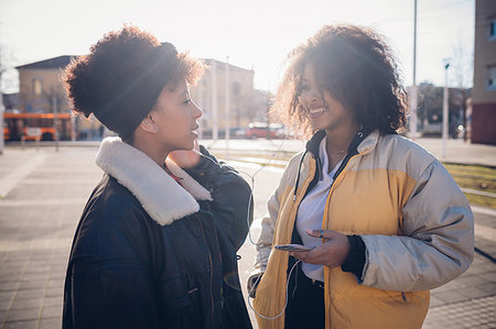 simsearch:649-09252022,k - Two cool young female friends sharing earphones on urban sidewalk Photographie de stock - Premium Libres de Droits, Code: 649-09268927