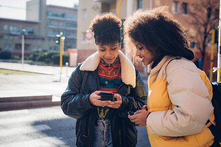 simsearch:649-09061458,k - Two cool young women looking at smartphone on urban sidewalk Stock Photo - Premium Royalty-Free, Code: 649-09268934