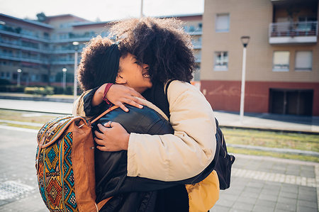 simsearch:649-09268931,k - Two young women hugging on urban sidewalk Fotografie stock - Premium Royalty-Free, Codice: 649-09268949