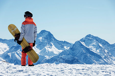 simsearch:649-08900389,k - Teenage boy snowboarder looking out over landscape from snow covered mountain top, rear view, Alpe-d'Huez, Rhone-Alpes, France Stock Photo - Premium Royalty-Free, Code: 649-09268965