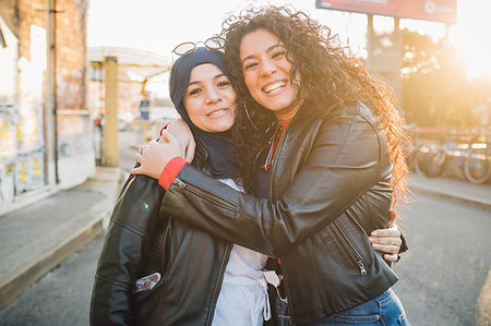 simsearch:649-09268931,k - Young woman in hijab and best friend hugging each other in city, portrait Fotografie stock - Premium Royalty-Free, Codice: 649-09269071