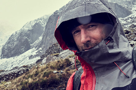 Male hiker with hood up in sleeting snow capped mountain landscape, close up portrait, Llanberis, Gwynedd, Wales Stock Photo - Premium Royalty-Free, Code: 649-09269131