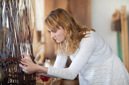 Young female basket maker weaving in workshop Foto de stock - Royalty Free Premium, Número: 649-09269169