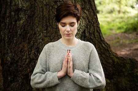 simsearch:649-09025835,k - Woman practising Reiki, large tree trunk in background Stock Photo - Premium Royalty-Free, Code: 649-09269288