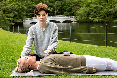 simsearch:614-08487979,k - Woman practising Reiki on grass lawn by river, London, UK Stock Photo - Premium Royalty-Free, Code: 649-09269294