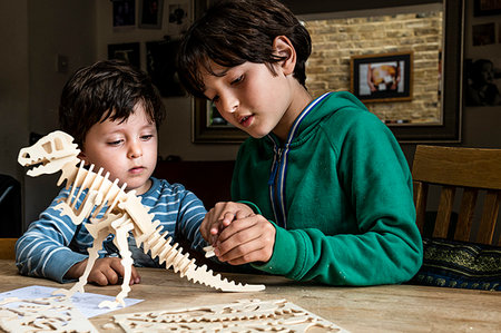 simsearch:649-09269303,k - Boy showing brother way to build wooden dinosaur Stock Photo - Premium Royalty-Free, Code: 649-09269304
