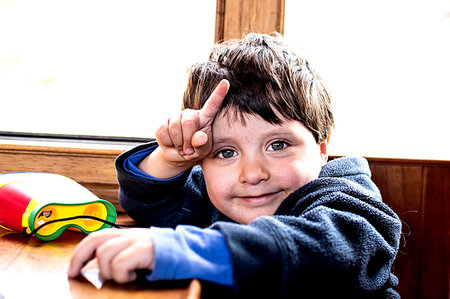 Cute boy smiling and pointing finger Stock Photo - Premium Royalty-Free, Code: 649-09269327