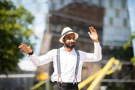 Man with panama hat dancing in city Fotografie stock - Premium Royalty-Free, Codice: 649-09269421