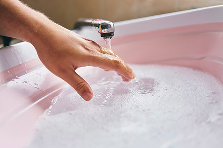 Hand testing temperature of water in basin Stock Photo - Premium Royalty-Free, Code: 649-09275899