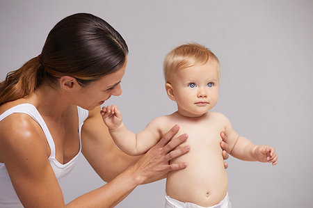 first steps mother - Mother supporting baby on feet Stock Photo - Premium Royalty-Free, Code: 649-09275925