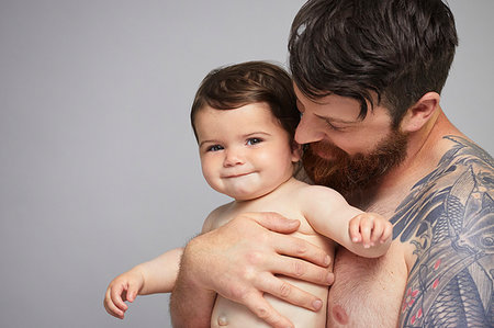 Bearded tattooed man holding a baby Stock Photos - Page 1 : Masterfile