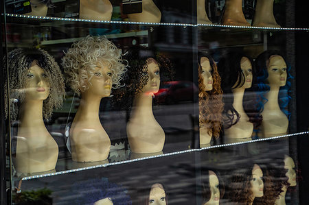 simsearch:6118-09079638,k - Row of mannequin heads displaying variety of wigs in shop window Foto de stock - Royalty Free Premium, Número: 649-09276159