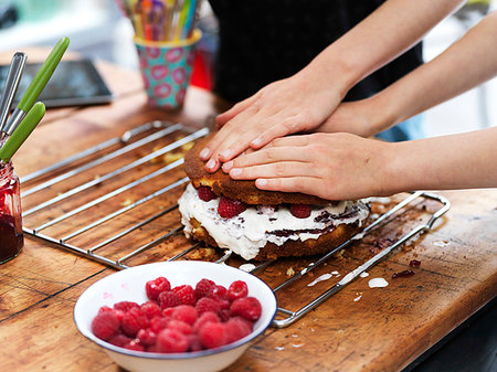 simsearch:614-09276703,k - Girl and her sister baking a cake, pressing down top layer at kitchen table, cropped view of hands Stock Photo - Premium Royalty-Free, Code: 649-09276205