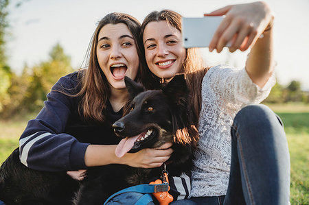 phone family selfie outside - Sisters taking selfie with dog in park Stock Photo - Premium Royalty-Free, Code: 649-09277322